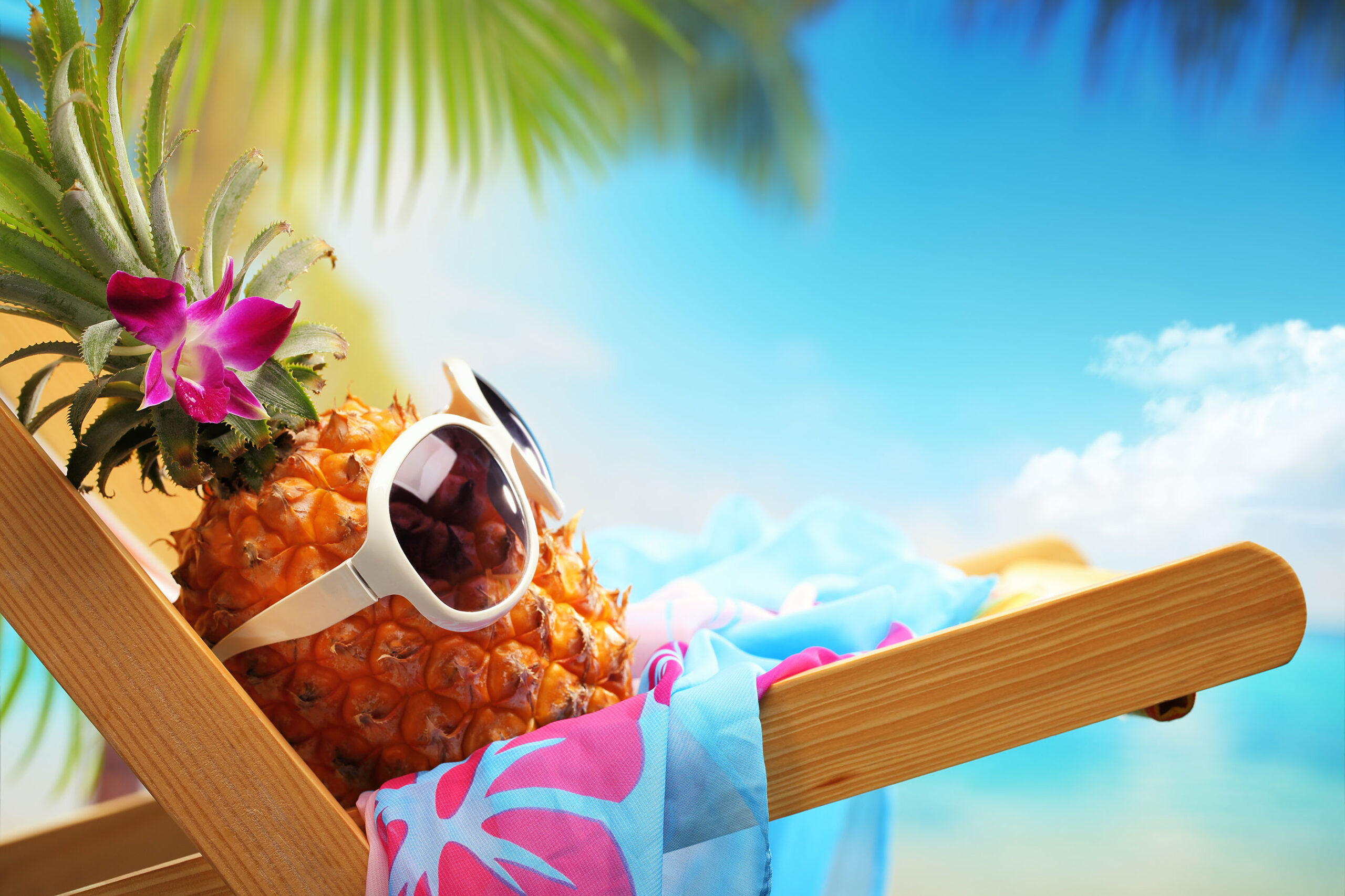A pineapple with glasses on, relaxing on a beach chair.